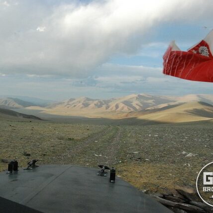 Wyprawa gazem 69 - polska flaga na tle gór