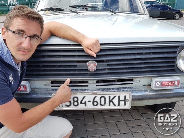 Tomasz Maciążek na tle białej Wołgi